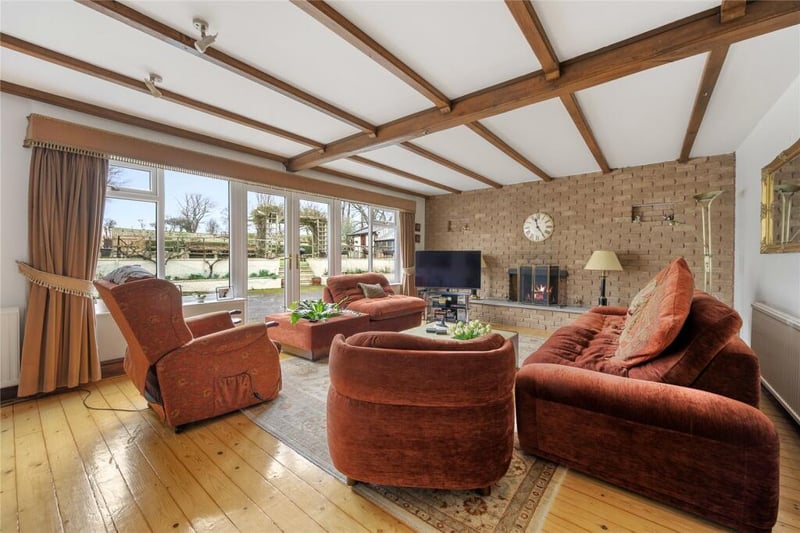 A gorgeous family room with a multi fuel fireplace and double doors leading onto the rear courtyard area.