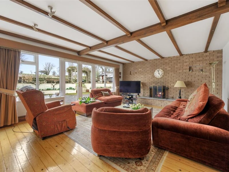 A gorgeous family room with a multi fuel fireplace and double doors leading onto the rear courtyard area.