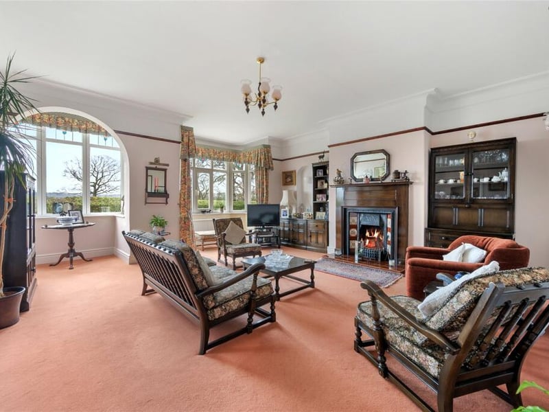 The formal sitting room features two large bay windows, a picture rail and reclaimed fireplace.