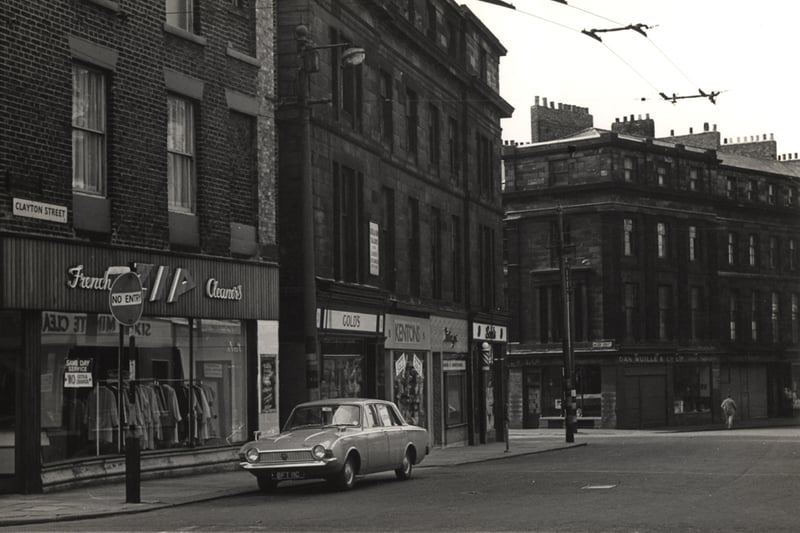 The photograph shows numerous shops and business including French Zip Cleaners Gold's Kenton's and Dan Wullie and Co. 