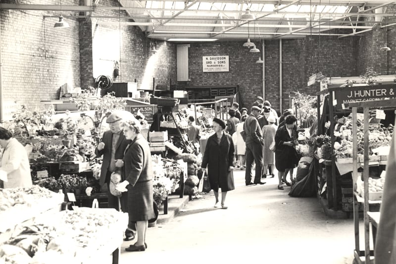 A view of the Green Market Clayton Street/St. Andrew's Street Newgate Street Newcastle upon Tyne taken in 1966. The photograph has been taken from Newgate Street looking up one of the aisles of the Green Market which is lined with fruit vegetable and flower stalls.