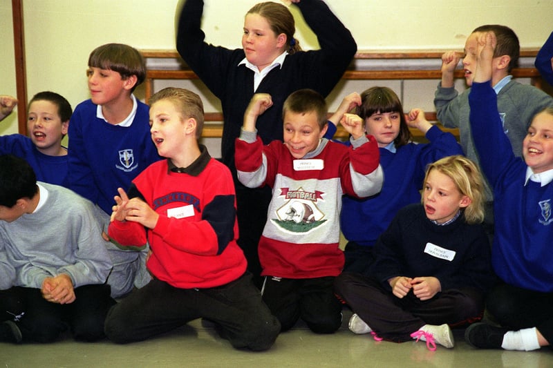 Pupils cheer as actors from the English Shakespeare Company perform a scene from Macbeth at their school in  November 1997.