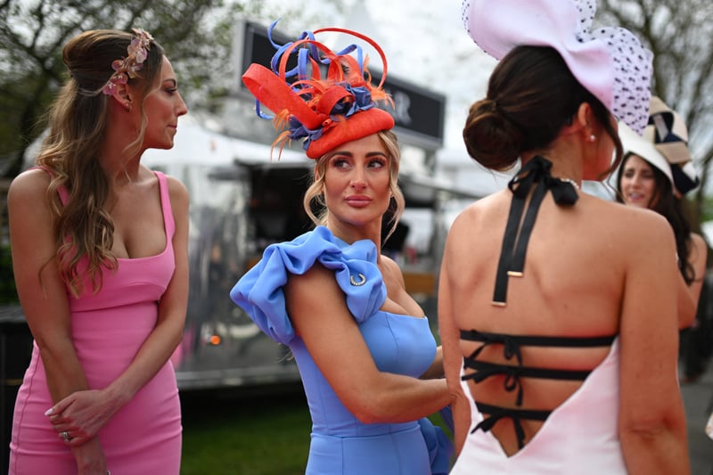 Racegoers arrive at Aintree Racecourse in stunning outfits and eye-catching head wear.