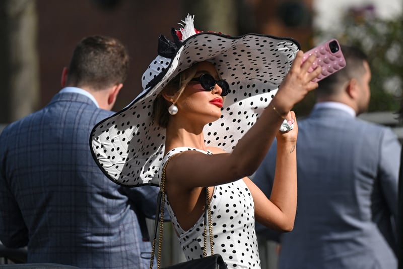 A racegoer takes a selfie in the sun to capture a moment as  she attends on Ladies Day.