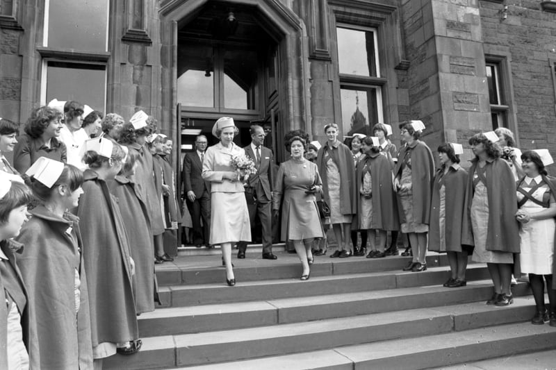 Nurses form a guard of honour as Queen Elizabeth II and Prince Philip Duke of Edinburgh leave the Royal Infirmary hospital in Edinburgh, July 1979.