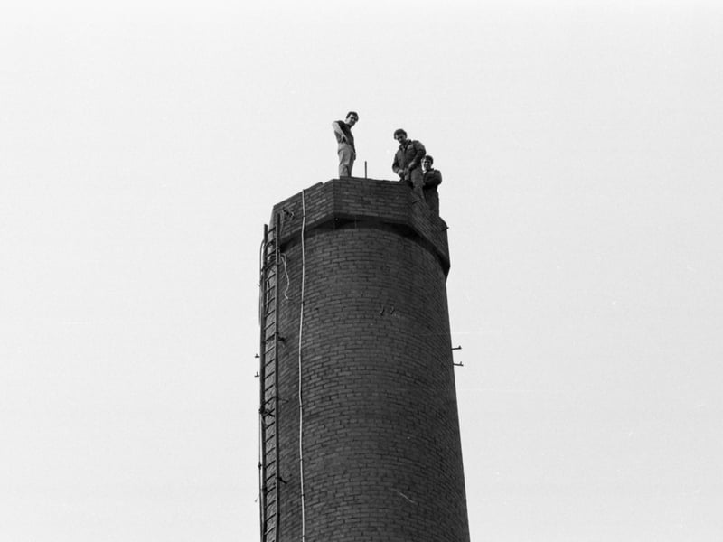 Three men stand on top of the the old boilerhouse chimney at the Royal Infirmary in Lauriston Place on the day the chimney was to demolished, February 1984.