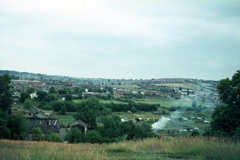  looking across Meanwood Valley towards Meanwood. On the left are derelict buildings of Woodlands Dyeworks, shortly to be demolished. Further back on the right is a rugby ground. Grove Lane runs across the centre of the picture with the junction with Bentley Lane on the left, leading up to Bentley Primary School, and that with Meanwood Road and Stainbeck Road towards the right. Pictured in July 1975.