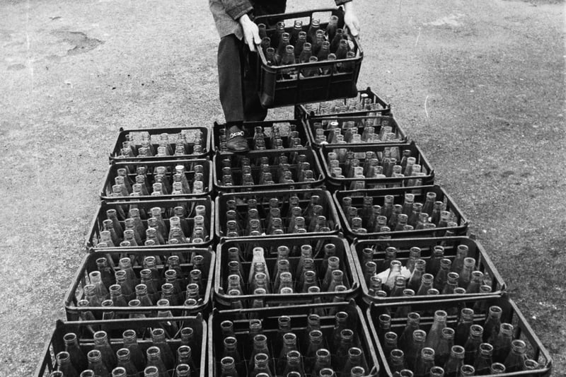 Caretaker Charles Matthews with some of the crates of milk bottles at St. Thomas Aquinas School in November 1973.