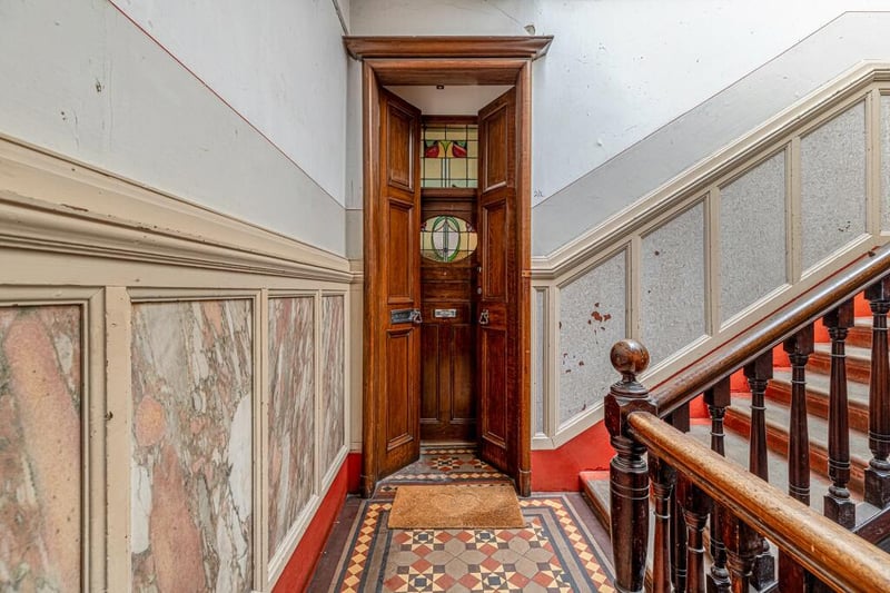 A look inside the communal close, with the flat being accessed on the second floor via double storm doors into entrance vestibule and front door with beautiful stained glass detailing.