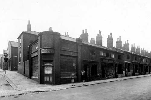 The corner of Green Road (Leeds 9) with Cherry Row, looking north-north-west. The properties, (including H. Burgon's butchers on the corner), are empty and derelict. To the left Pollard Street is just visible. Two children play on the corner. Pictured in June 1945.