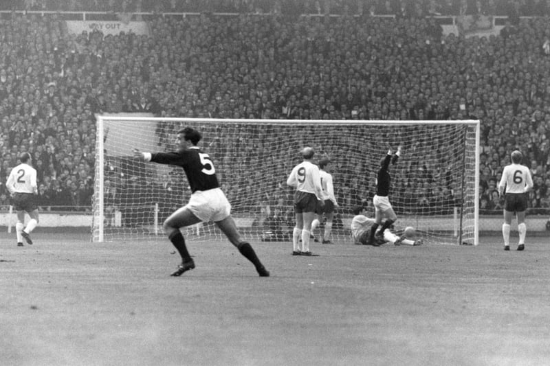 Scotland's inside-left, Denis Law (second from right), raises both arms after scoring the opening goal at Wembley.