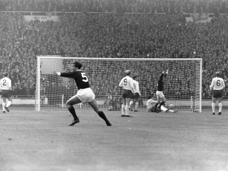 Scotland's inside-left, Denis Law (second from right), raises both arms after scoring the opening goal at Wembley.