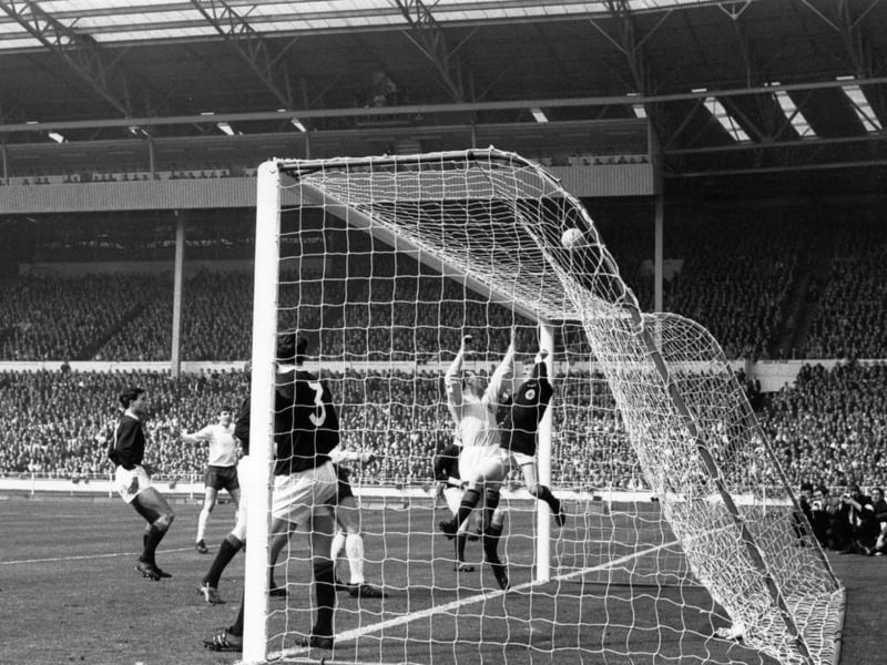 Scotland goalkeeper Ron Simpson tips the ball over the bar, alongside teammate Billy Bremner, to fend off an England attack.