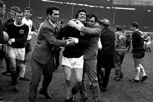 Jim Baxter is hugging by joyous Scotland fans after the famous 3-2 win.
