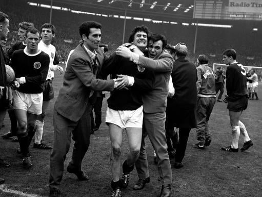 Jim Baxter is hugging by joyous Scotland fans after the famous 3-2 win.