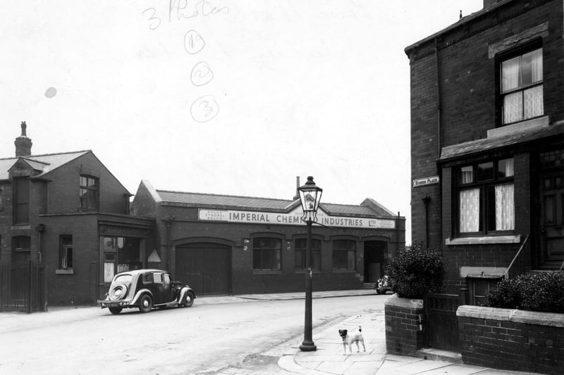 Premises of Imperial Chemical Industries Ltd (ICI), paints division, on Hudson Road viewed from Hudson Place. On the left of ICI is Pickup and Smith's bakers shop. There is a car parked outside the shop. In view is the bay window and small walled garden of the first house in the terrace on Hudson Place. There is a lamp post and a dog on the corner of the street. Pictured in July 1958.