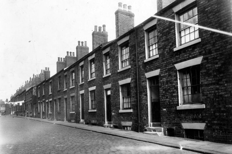 Old type back-to-back houses on Recovery Street pictured in July 1949. Washing hanging across street.