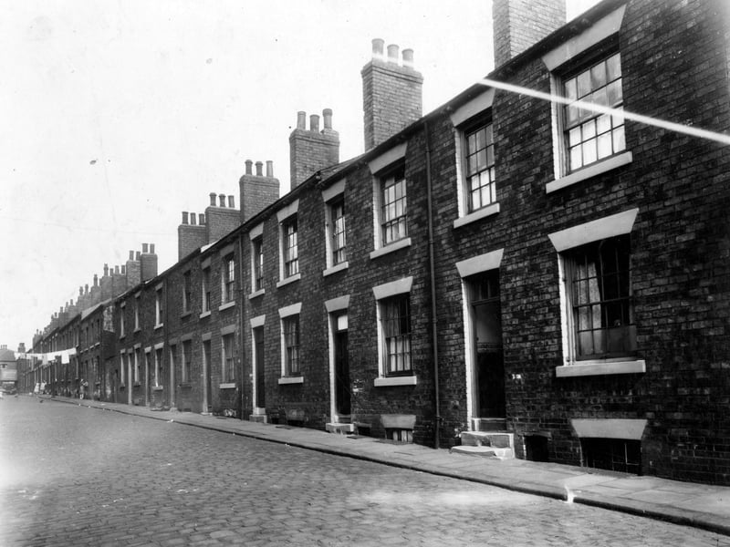 Old type back-to-back houses on Recovery Street pictured in July 1949. Washing hanging across street.