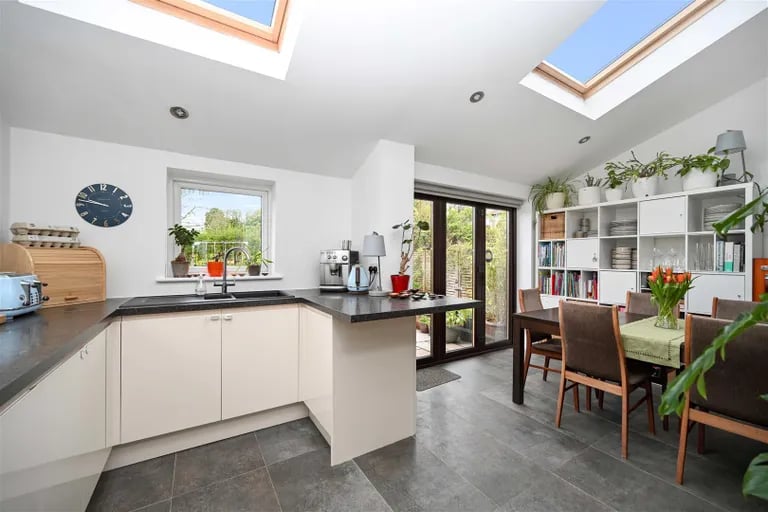 The kitchen opens up to a gorgeous dining area with skylights over.