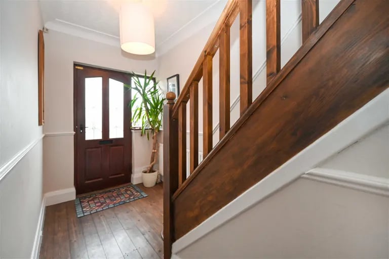 As you enter, you're greeted by an inviting entrance hall with wooden floors.
