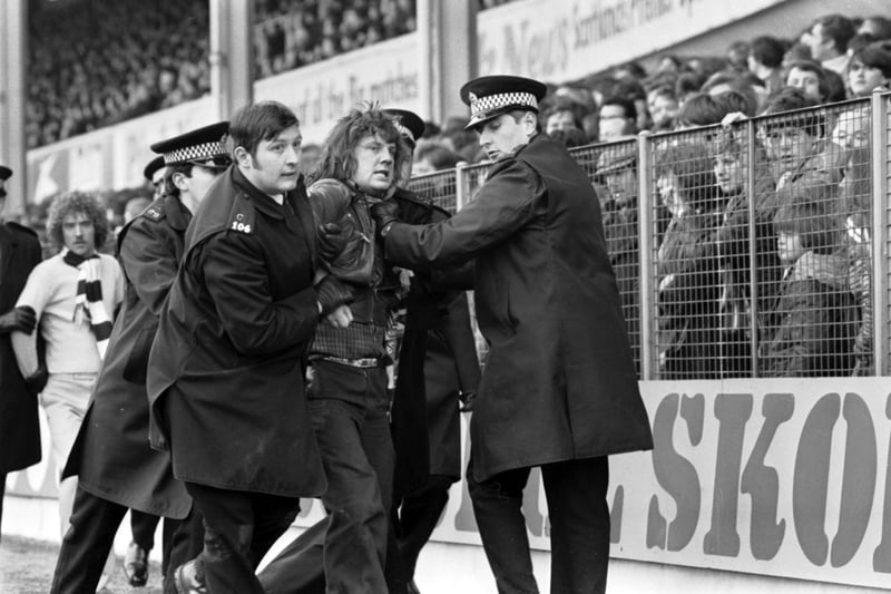 Police remove Hibs fans from the ground after crowd trouble during the Hibs v Hearts Edinburgh Derby at Easter Road in March 1979.