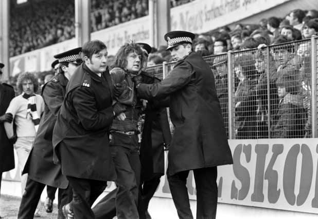 Police remove Hibs fans from the ground after crowd trouble during the Hibs v Hearts Edinburgh Derby at Easter Road in March 1979.