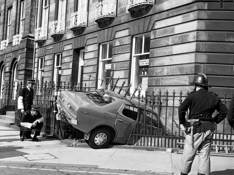 Police and firemen attend when a car crashes through the railings at the corner of Randolph Place in Edinburgh, September 1975.