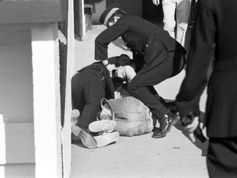 Police grapple with a football suporter after crowd trouble breaks out during the Hearts v Hibs Edinburgh Derby match at Tynecastle in August 1978.