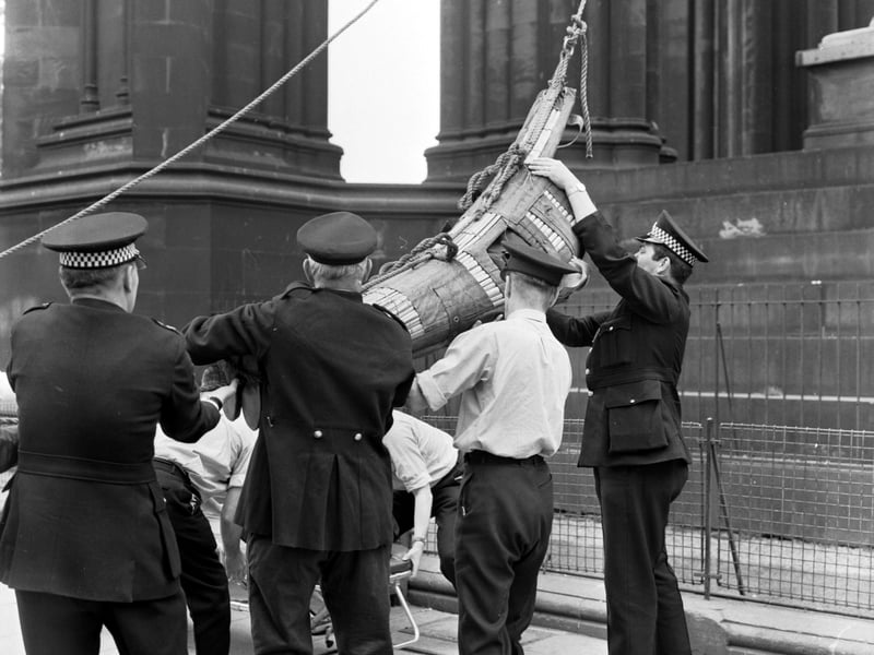 An American tourist had to be rescued and lowered to the ground in a stretcher from the Scott Monument in Princes Street, Edinburgh, in August 1970. Here, he is attended by police and ambulance men.