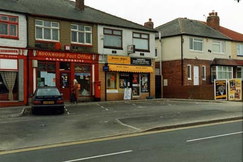 York Road in March 1991. In focus are Rookwood Post Office, Sanghera Rookwood Stores, off licence, newsagent and videos, and a medical centre with two small advertising hoardings on the wall outside. A car is parked in one of the parking spaces marked out in front of the shops. Neville & Jill's hairdressers, can just be seen on the left.