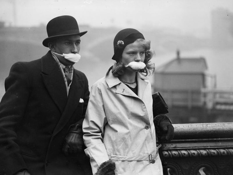 Pedestrians in a London street wearing masks over their mouths in an effort to avoid catching flu on the advice of a London doctor who suggested that the influenza 'germs' are spread from the mouth by speaking and coughing.  (Photo by Fox Photos/Getty Images)