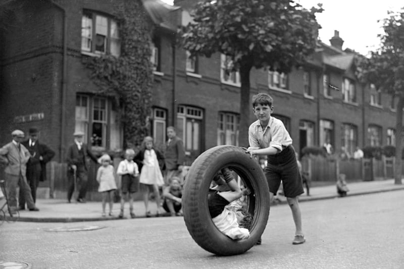 August 1 1931:  Children race with motor car tyre in Hornsey, London.  (Photo by Fox Photos/Getty Images)
