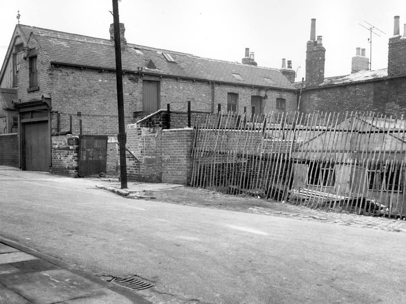 Folly Lane on the far left with the Good Physician Church of England Mission Room behind. On the right is the entrance to a yard with warehouses and sheds shown on the far right behind the fence. Pictured in October 1963.