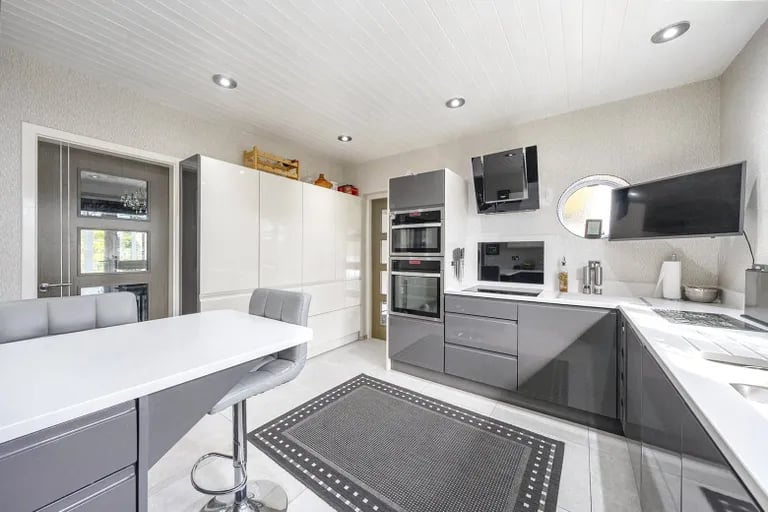 The kitchen has been fitted with contemporary worktops extended into a breakfast bar.