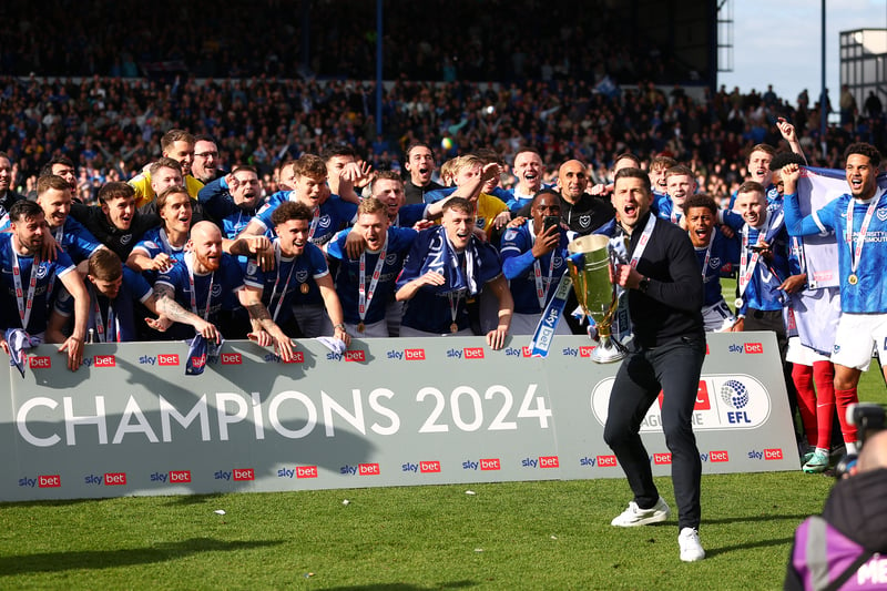 Pompey head coach John Mousinho lifts them League One trophy with the Pompey players behind him following today's game against Wigan at Fratton Park