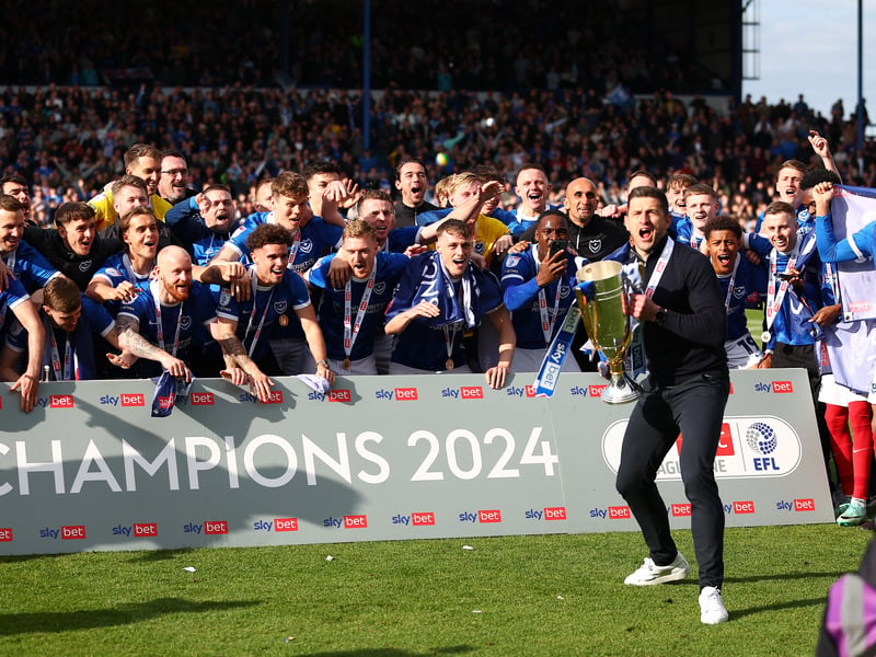 Pompey head coach John Mousinho lifts them League One trophy with the Pompey players behind him following today's game against Wigan at Fratton Park