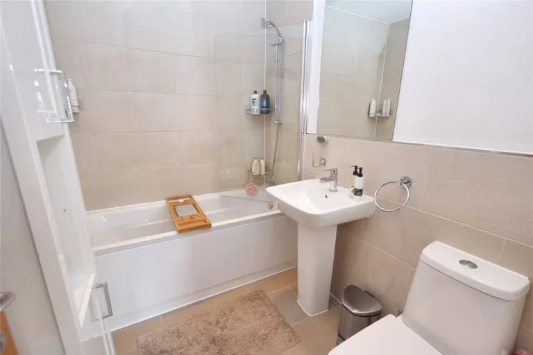 A contemporary stylish bathroom with shower over bath.