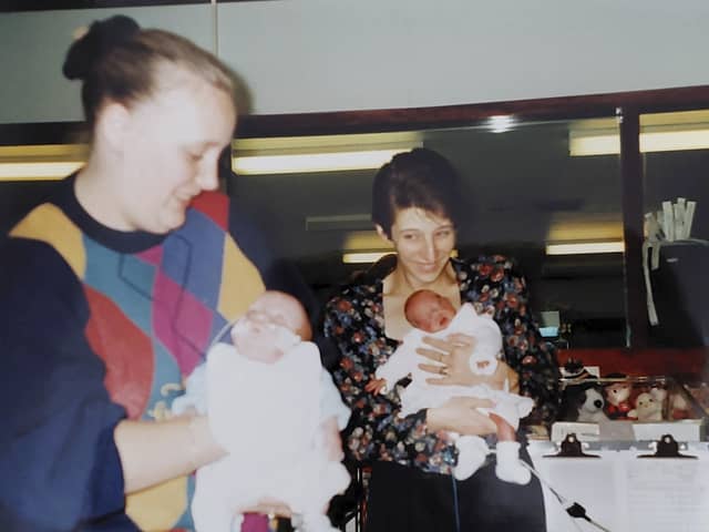 Bronwyn is held by mum Debbie as a baby, and Jack is held by mum Sharon.