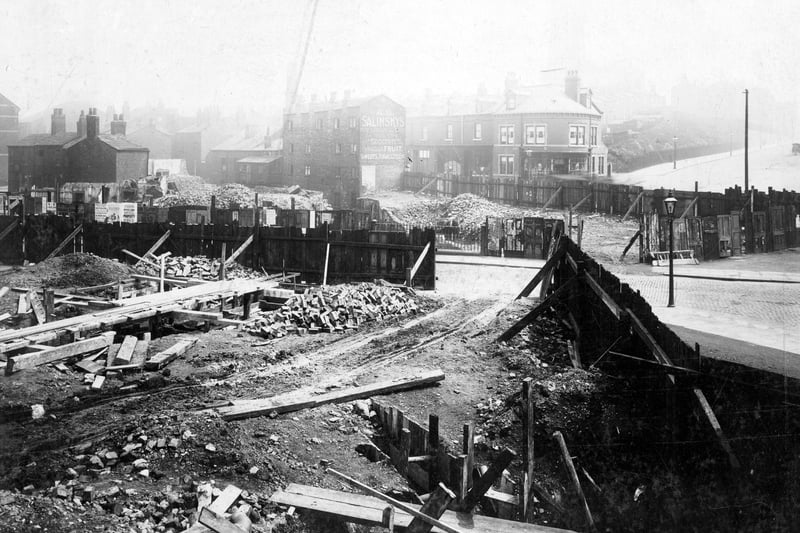 Thre construction of a roundabout  at the junction of Mabgate, Regent Street and Quarry Hill. This was part of the building of New York Road, following the line of Hope Street. This view of the construction site is from Regent Street, looking towards Mabgate. Abraham Salinskys' grocers shop is at number 25 Mabgate. On the opposite side at number 20 Mabgate, Harry Groves barber, next right at 18, Mrs B Hamling, wardrobe dealer. The corner property is that of James Drewery, chemist. Pictured in July 1909.