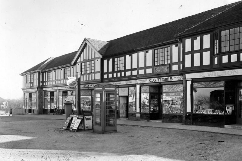 Sandhill Parade on the east side of Harrogate Road in February 1952. Shops shown are R. Wilson and Sons fruitiers, C.G. Timmis newsagent and post office, A.Cawood drapers. nos. 590-596 is the Leeds Industrial Co-operative Society Society Ltd. (including a pharmacy and a butchers). A telephone box and a post box are in the foreground.