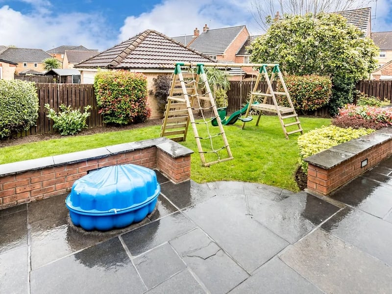 The garden has lawn and patio areas, with plenty of space for children to play.
