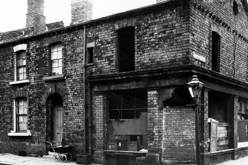Arkwright Street in October 1963. A back-to-back terraced house on the left of the image, number 29 with a coach built pram parked outside. On the right is number 31, here was a shop at the corner with Arkwright Road however the windows and door have been boarded up or bricked up. On the right is Arkwright Road.