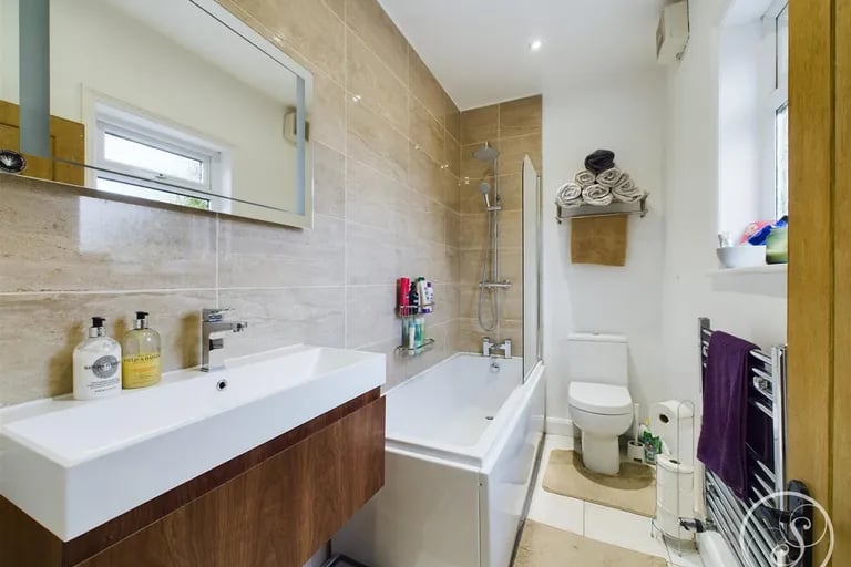 The semi-tiled house bathroom is on the ground floor and features a shower over bath.