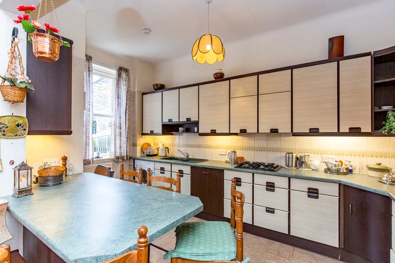 The kitchen is generously appointed with base and wall-mounted cabinets and downlit worksurfaces, backed by splashback tiles. It is fitted with a breakfast bar and has additional built-in storage, as well as a range of integrated appliances.