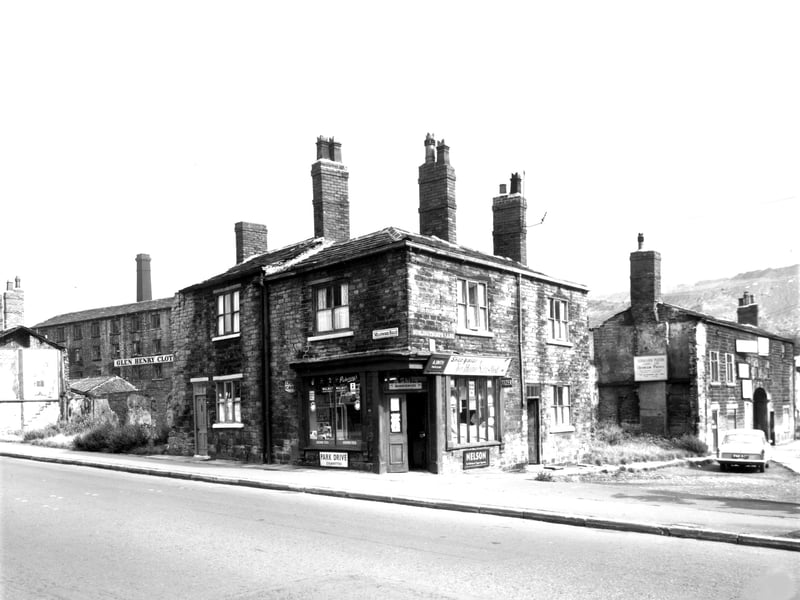 Meanwood Road runs from the left edge of this photo from August 1962. In the background, the factory premises of Glen, Henry and Hollis Ltd, wholesale clothing manufacturers is visible. In the centre number 284 Meanwood Road is a residential property with a grocers at number 282, business of A. Smith. Buslingthorpe Lane then runs to the right edge. Number 142, next to the shop, is a residential property with number 136 on the right edge, the premises of Aluminium Platers Leeds Ltd. In the background there appears to be a quarry.