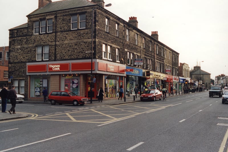  A view of the High Street Gosforth taken in 1998. The photograph shows a row of shops on one side of the High Street. The shops include 'Thomas Cook' and 'Oxfam'.