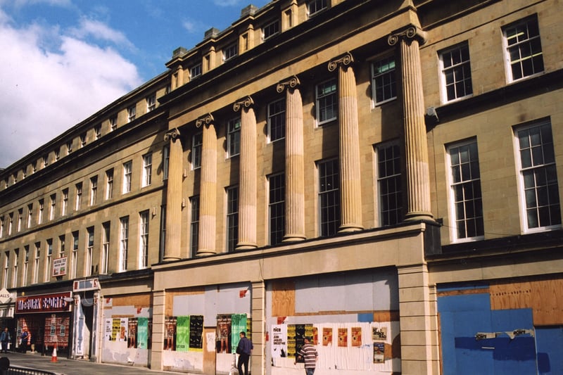 A view of Grainger Street Newcastle upon Tyne taken in 2002. The photograph shows the frontage of buildings on Grainger Street. 'Ball's' and 'McGurk Sports' are on the ground floor of the buildings. The other shops are empty and boarded up. 
