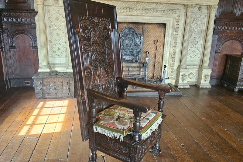 The unique wooden chair in the Great Oak Room has a unique feature: it can be transformed to be used as either a chair or table.