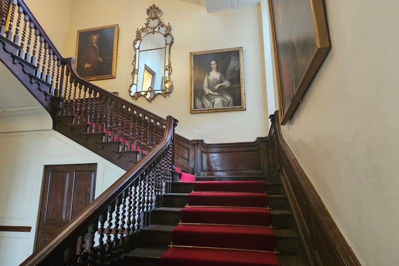 The staircase was built in 1731 on the site of an original turret staircase. Paintings on the stairwell feature John and Mary Henley who owned and remodelled the lodge in 1730 and Robert Yeamans, a Mayor and Royalist MP in Parliament, who was executed during the Civil War.