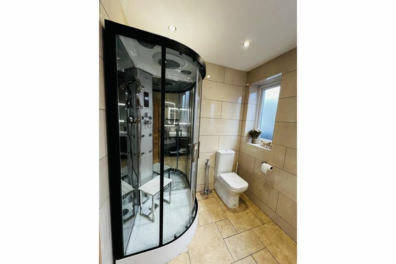 The bathroom has a large and modern shower.